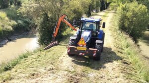 tracteur bleu avec le broyeur au bras